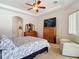 Bright bedroom features a ceiling fan, television, and relaxing seating area with a leather recliner at 12637 Tyler Run Ave, Odessa, FL 33556