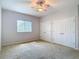Bedroom featuring carpeting, a window, and double door closet with a ceiling fan at 12637 Tyler Run Ave, Odessa, FL 33556