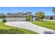 Lovely home featuring three-car garage, a large paved driveway, and a manicured lawn at 12637 Tyler Run Ave, Odessa, FL 33556