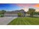 Beautiful single-story home featuring a well-manicured lawn, three-car garage and elegant architectural details at 12637 Tyler Run Ave, Odessa, FL 33556
