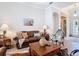 Cozy living room furnished with leather couches, cowhide accents, large windows, and neutral tile flooring at 12637 Tyler Run Ave, Odessa, FL 33556