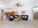 Bright living room is open to the kitchen and features a ceiling fan and a view of the stairs at 12637 Tyler Run Ave, Odessa, FL 33556