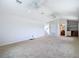 Open-concept living room with carpet, fan, next to a space with cabinets and shelving; ample lighting at 12637 Tyler Run Ave, Odessa, FL 33556