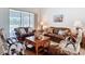 Cozy living room furnished with leather couches, cowhide accents, large windows, and neutral tile flooring at 12637 Tyler Run Ave, Odessa, FL 33556