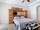 Main bedroom includes built-in storage and television, ceiling fan, and plush carpet at 12637 Tyler Run Ave, Odessa, FL 33556