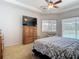 Comfortable main bedroom with ceiling fan, television and a view of the pool at 12637 Tyler Run Ave, Odessa, FL 33556