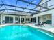 Screened-in pool area featuring chaise lounges, lush potted plants, and backyard views at 12637 Tyler Run Ave, Odessa, FL 33556