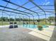 Screened-in pool area with chaise lounges, lush landscaping, and views of the expansive backyard at 12637 Tyler Run Ave, Odessa, FL 33556