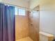 Shower featuring tiled walls, a showerhead with a caddy, a window, and a shower curtain at 12637 Tyler Run Ave, Odessa, FL 33556