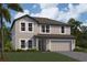 Charming two-story home boasts lush landscaping, a two-car garage, and a welcoming facade at 12801 Castle Oaks Dr, Hudson, FL 34669