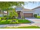 Charming home with tropical landscaping, manicured lawn, and a welcoming two-car garage at 13113 Green Violet Dr, Riverview, FL 33579