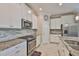 Well-lit kitchen featuring granite countertops, stainless steel appliances, and sleek white cabinetry at 13113 Green Violet Dr, Riverview, FL 33579