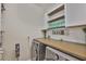 Well-organized laundry room featuring modern appliances, ample counter space, and stylish shelving at 13113 Green Violet Dr, Riverview, FL 33579