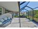 Spacious covered patio with lounge seating overlooking the manicured backyard, ideal for relaxing or entertaining at 13113 Green Violet Dr, Riverview, FL 33579