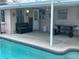 An inviting backyard pool with a patio area, bench, and picnic table, perfect for outdoor relaxation and entertainment at 13605 Stacey Dr, Hudson, FL 34667