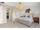Bedroom with a large bed, two side tables, modern lighting, decorative wall art and view to an en-suite bathroom at 14317 Eagle Branch Dr, Nokomis, FL 34275