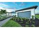 Charming home with a three-car garage, stone walkway, well-manicured lawn and vibrant landscaping at 14317 Eagle Branch Dr, Nokomis, FL 34275