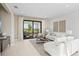 Living room features sliding glass doors to patio, lots of natural light, comfortable furniture, and decorative wall art at 14317 Eagle Branch Dr, Nokomis, FL 34275