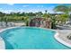 Beautiful pool featuring a rock waterfall, shallow entry, and lush tropical landscaping at 14317 Eagle Branch Dr, Nokomis, FL 34275
