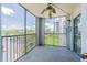 Screened balcony with a ceiling fan boasts views of the surrounding building, landscaping and parking at 14820 Rue De Bayonne # 301, Clearwater, FL 33762