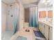 Bright bathroom with double sinks, shower and tub, with light blue walls and cream tile at 14820 Rue De Bayonne # 301, Clearwater, FL 33762