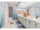 Well-lit bathroom featuring double vanity sinks and separate shower and tub area at 14820 Rue De Bayonne # 301, Clearwater, FL 33762
