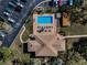 Aerial view of the community clubhouse and pool with palm trees and parking areas; perfect for recreational living at 1729 Seascape Cir # 102, Tarpon Springs, FL 34689