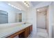 Bathroom with a long vanity, large mirror, updated lighting and a walk-in shower at 1729 Seascape Cir # 102, Tarpon Springs, FL 34689
