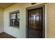 Condo entrance with a storm door, window with curtains, a doormat, and beige exterior walls at 1729 Seascape Cir # 102, Tarpon Springs, FL 34689