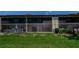 Rear exterior view showcasing screened lanais perfect for outdoor relaxation, overlooking a green lawn at 1729 Seascape Cir # 102, Tarpon Springs, FL 34689