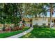 Inviting condo exterior with lush landscaping, walkway and a view of the two-story building at 1729 Seascape Cir # 102, Tarpon Springs, FL 34689