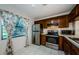 Bright kitchen featuring stainless appliances, wood cabinets, and tiled floors with a window at 1729 Seascape Cir # 102, Tarpon Springs, FL 34689