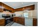 Bright kitchen featuring stainless oven, microwave, and dishwasher with wood cabinets at 1729 Seascape Cir # 102, Tarpon Springs, FL 34689