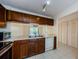 Well-equipped kitchen featuring light countertops, white appliances, and tile floors at 1729 Seascape Cir # 102, Tarpon Springs, FL 34689