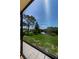 Screened lanai view of a lush lawn and a serene pond at 1729 Seascape Cir # 102, Tarpon Springs, FL 34689