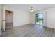 Living room features wood-look floors and sliding glass doors opening to the backyard at 1729 Seascape Cir # 102, Tarpon Springs, FL 34689