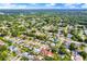Expansive aerial view of a neighborhood with tree-lined streets and well-maintained homes, some featuring backyard pools at 17838 Morninghigh Dr, Lutz, FL 33549