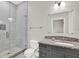 Bathroom with stand up shower featuring white marble tiling and granite topped vanity with storage at 17838 Morninghigh Dr, Lutz, FL 33549