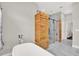 Bathroom featuring a soaking tub next to a walk-in shower with a custom wood panel at 17838 Morninghigh Dr, Lutz, FL 33549