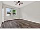 Empty bedroom with hardwood floors, ceiling fan, bright lighting, and a window at 17838 Morninghigh Dr, Lutz, FL 33549