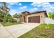 Stunning home with an attached garage, well-maintained lawn, and beautiful landscaping at 17838 Morninghigh Dr, Lutz, FL 33549