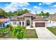 Inviting single-story home with a stone accent facade, arched entryway, and a lush front yard at 17838 Morninghigh Dr, Lutz, FL 33549