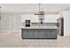 Kitchen features a gray island with granite countertops, white cabinets and modern appliances at 17838 Morninghigh Dr, Lutz, FL 33549