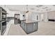 Open kitchen featuring stainless steel appliances, white cabinets, and center island at 17838 Morninghigh Dr, Lutz, FL 33549