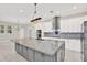 Kitchen featuring gray island with granite countertop, stainless steel appliances and designer backsplash at 17838 Morninghigh Dr, Lutz, FL 33549