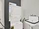 Laundry area with stacked washer and dryer, modern sink, and window to exterior at 17838 Morninghigh Dr, Lutz, FL 33549