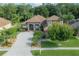 Aesthetic home featuring a well-manicured lawn, desert landscaping and arched entry at 18434 Eastwyck Dr, Tampa, FL 33647