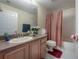 Traditional bathroom with single vanity, shower-tub combo with a red striped shower curtain at 18434 Eastwyck Dr, Tampa, FL 33647