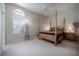 Comfortable bedroom features four-poster bed, neutral carpet and color scheme at 18434 Eastwyck Dr, Tampa, FL 33647