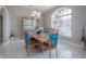 Dining room featuring modern table, elegant chairs, and a cabinet for display, illuminated by natural light at 18434 Eastwyck Dr, Tampa, FL 33647